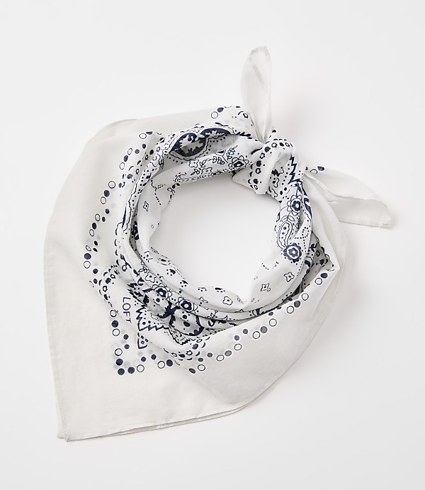A white bandana with a blue paisley pattern is tied in a knot against a plain white background.