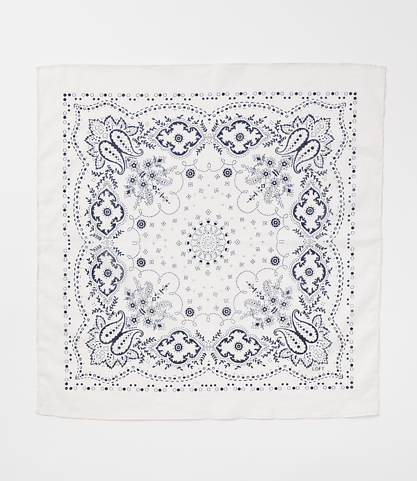 A white bandana with a blue paisley pattern is laid flat against a white background.