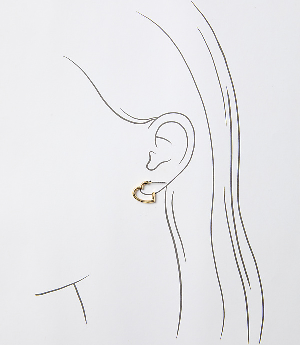 A delicate gold heart-shaped earring adorns an ear, outlined against a simple, light background.