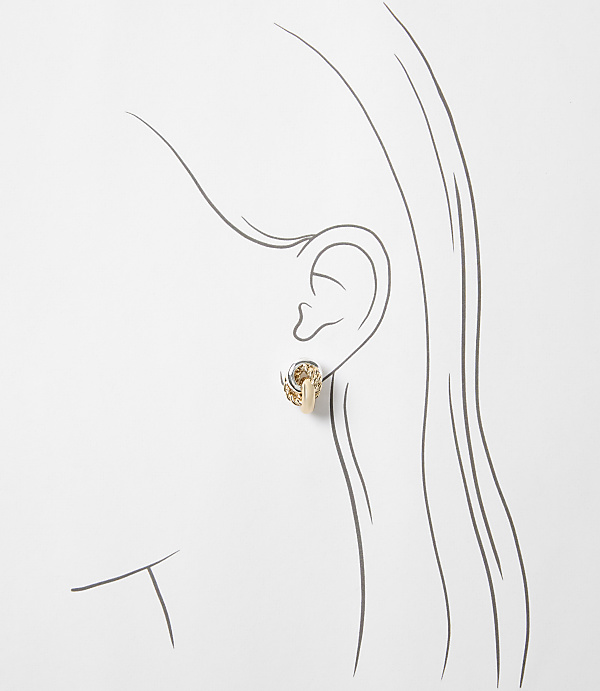 A delicate gold earring with intricate detailing adorns a stylized ear against a plain white background.