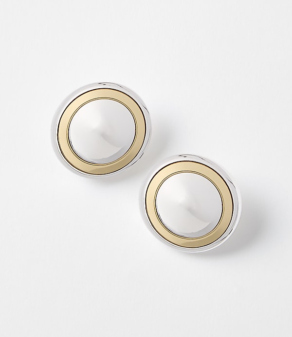 Two silver and gold circular earrings rest on a plain white background.