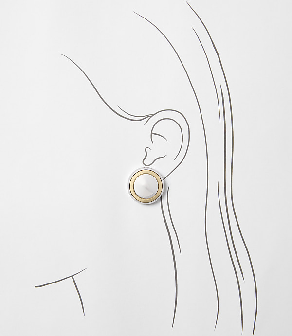 A silver and gold circular earring is worn on a sketched ear, with flowing hair lines extending into a plain white background.