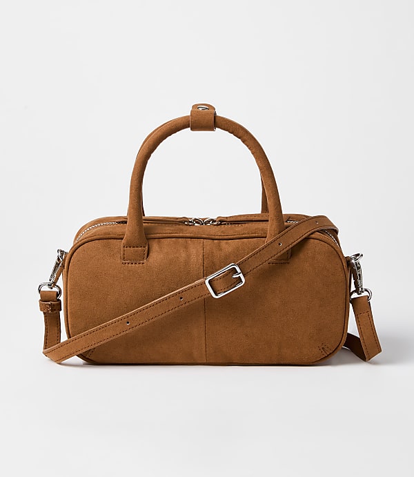 A brown suede duffel bag with a crossbody strap rests on a plain white background.