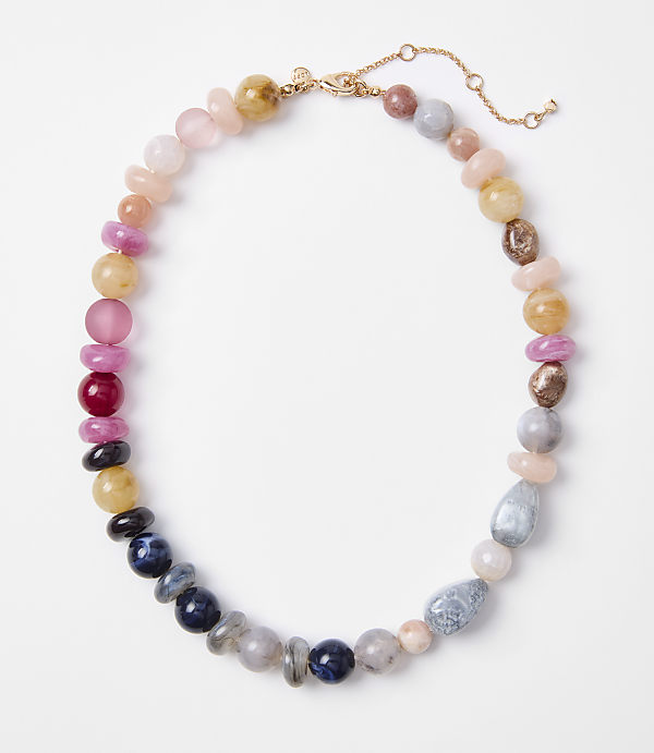A colorful beaded necklace with various stones is laid out on a plain white background.