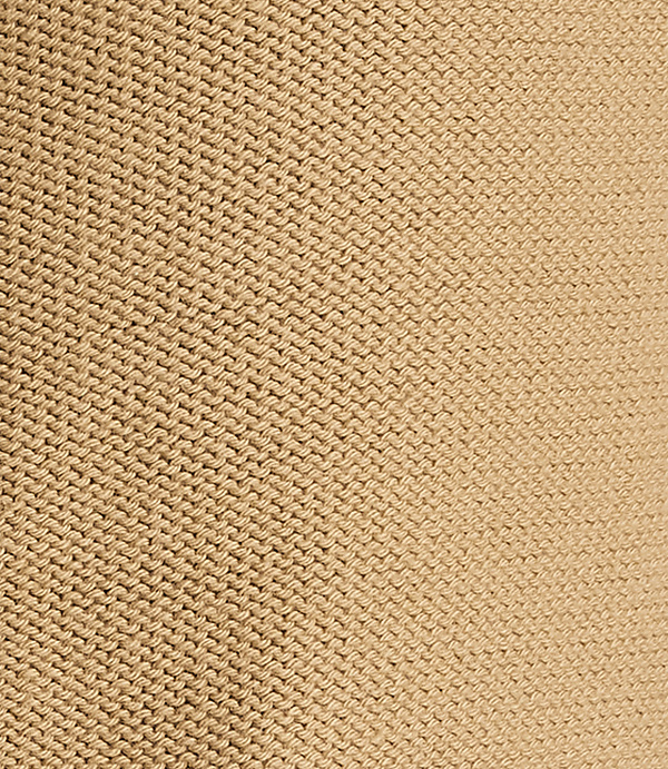 A close-up view of a beige knitted fabric fills the frame, with the texture of the stitches clearly visible throughout.