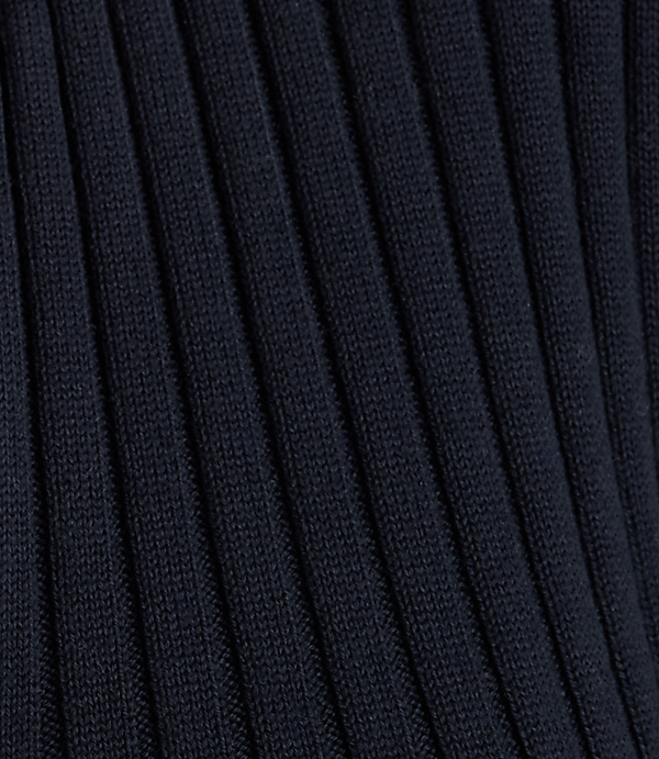 Dark navy ribbed fabric fills the frame, with the texture of the knit creating a sense of depth.