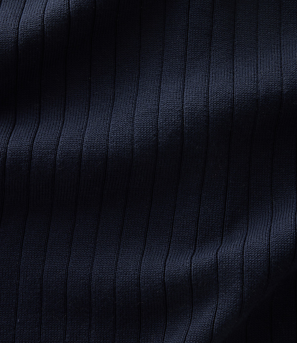 Dark navy ribbed fabric with vertical folds and shadows fills the frame.