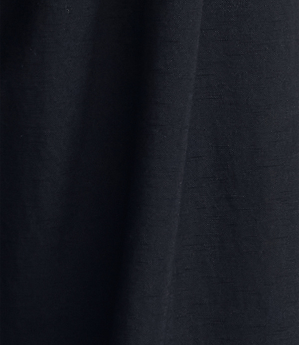 Dark, textured fabric folds in the foreground against a similarly dark, indistinct background.