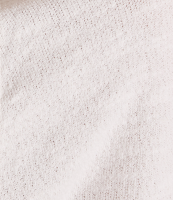 A close-up of a textured, light-colored fabric fills the frame, with subtle shadows and folds creating depth.