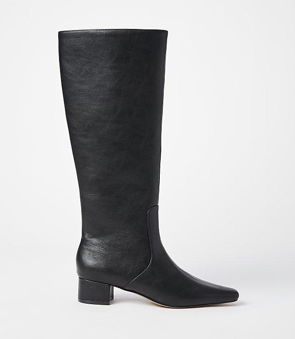 A black leather knee-high boot with a pointed toe and block heel stands against a plain white background.