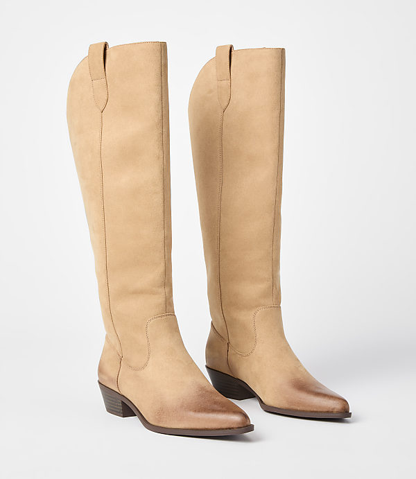 A pair of tan leather knee-high boots with pointed toes and a slight heel stand on a white background.