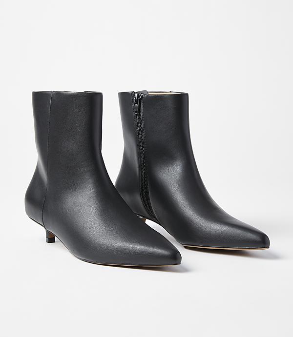 A pair of black leather kitten heel ankle boots with pointed toes are displayed against a plain white background.