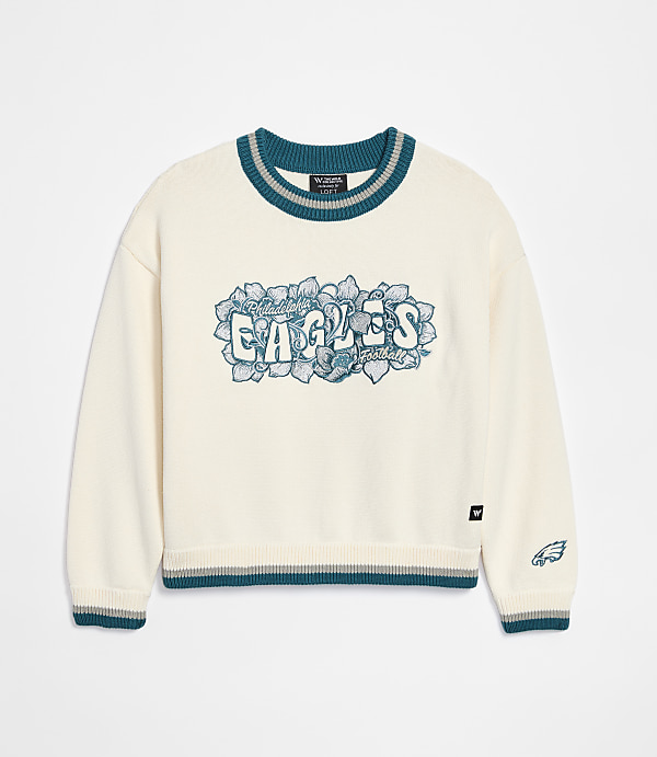A cream-colored sweater with "Philadelphia Eagles" emblazoned across the chest in teal and gray lettering is displayed against a plain white background.