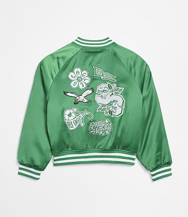 A green satin bomber jacket with various embroidered patches is displayed against a plain white background.