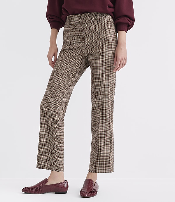 A person stands in plaid pants and burgundy loafers against a plain white background.