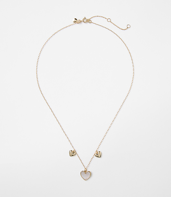 A delicate rose gold necklace with a heart-shaped pendant and two smaller heart charms hangs against a plain white background.