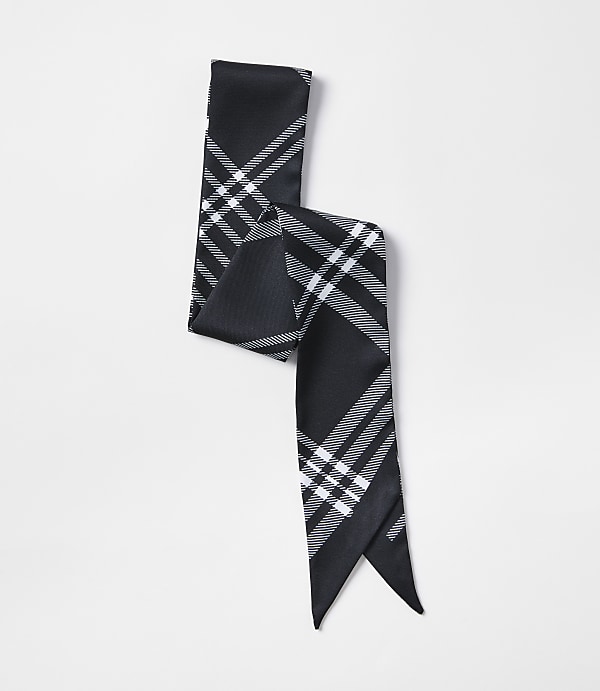 A black and white plaid scarf is laid out on a plain white background.