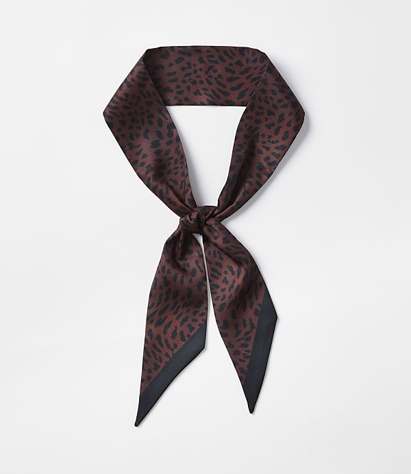 A brown leopard-print silk scarf with a black border is tied in a knot against a plain white background.