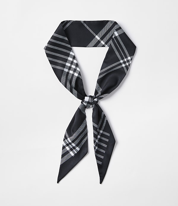 A black and white plaid scarf is tied in a knot in the foreground against a plain white background.