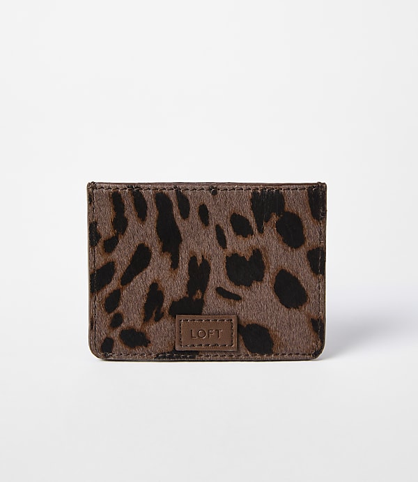 A small, brown leopard-print cardholder with a "LOFT" logo sits against a plain white background.