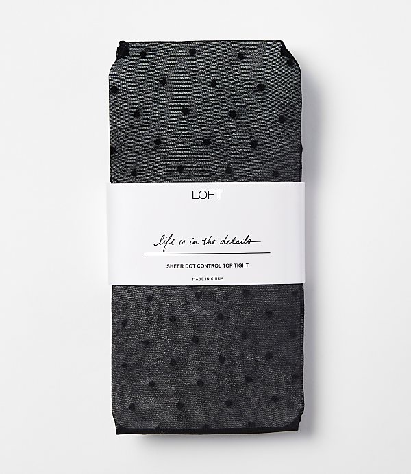 A pair of black sheer polka dot tights are neatly folded with a white band around them, set against a plain white background.