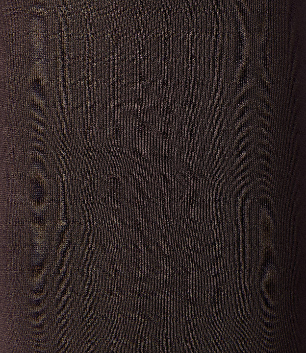 A close-up of dark brown ribbed fabric fills the frame, with subtle variations in light and shadow creating depth.