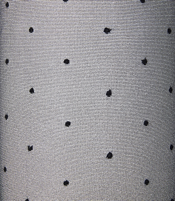Black polka dots are scattered across a textured, light gray fabric background.