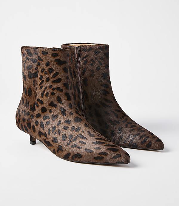 A pair of leopard-print calf-hair ankle boots with pointed toes and kitten heels are displayed against a plain white background.