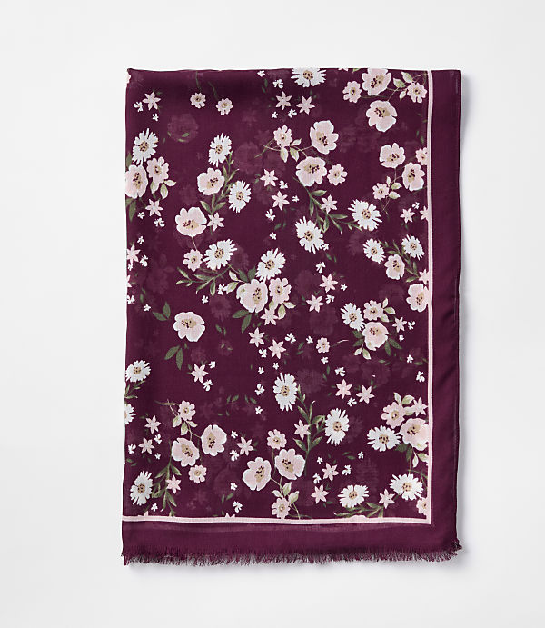 A burgundy scarf with a delicate floral pattern of white and pink flowers is laid flat against a plain white background.