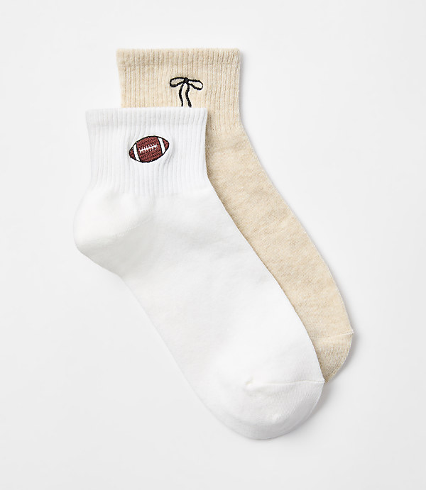 Two striped ankle socks, one burgundy and white, the other blue and white, lie on a plain white background.