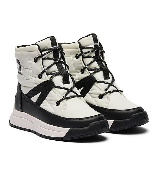 A pair of white and black quilted winter boots with black laces are displayed against a plain white background.