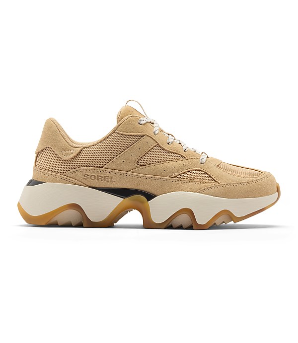 A tan suede and mesh Sorel sneaker with a chunky cream and tan sole is presented against a plain white background.