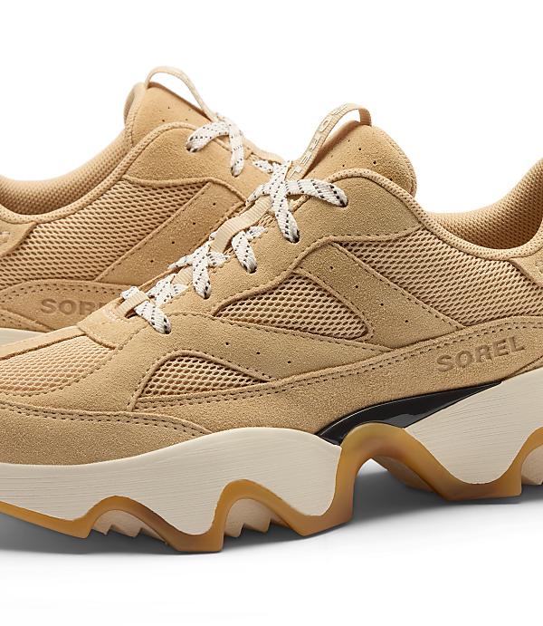 A pair of tan suede and mesh Sorel sneakers with chunky cream and tan soles are displayed against a plain white background.