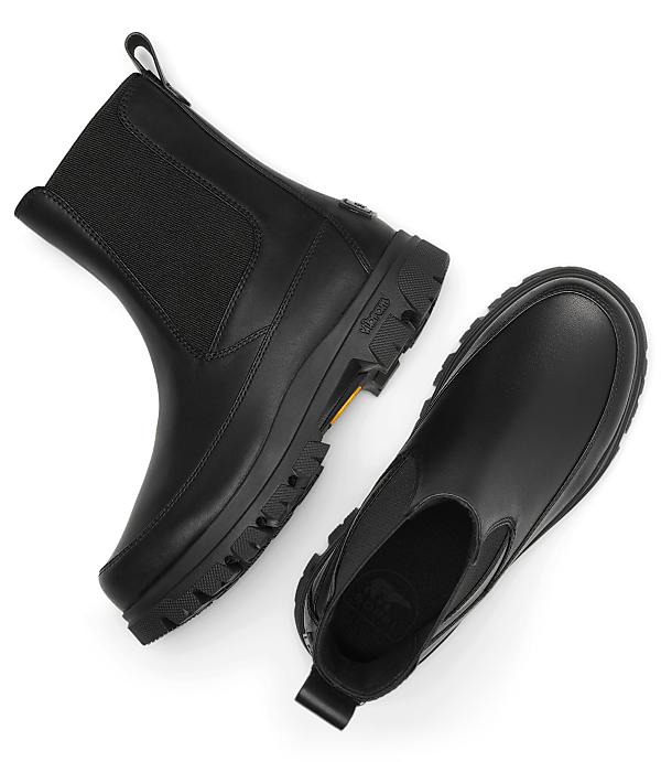 A pair of black leather Chelsea boots with thick soles are laid out on a plain white background.