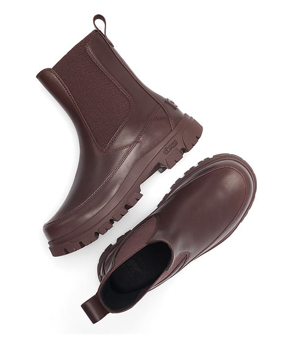 A pair of brown leather Chelsea boots with thick soles are arranged on a white background.