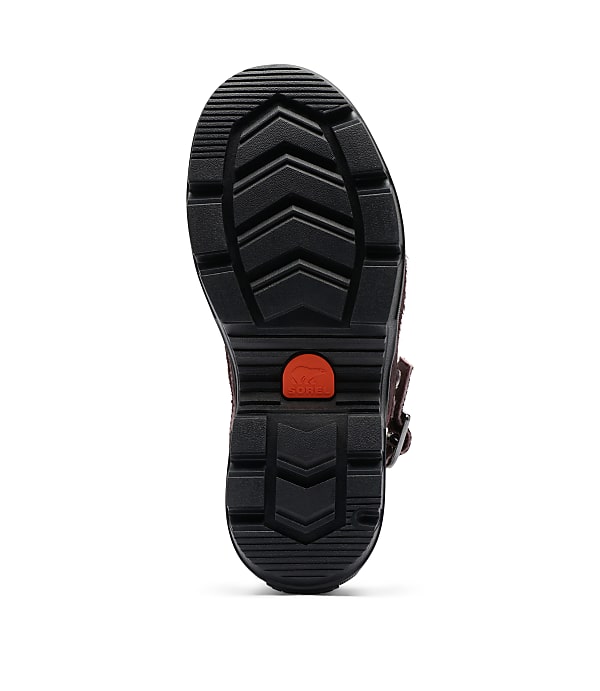 A black lug sole boot with a red accent is shown against a plain white background.