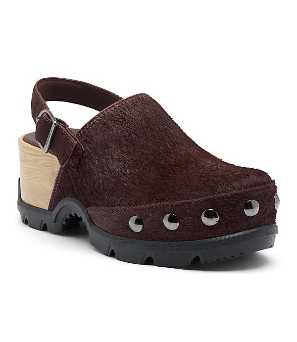 A burgundy, furry clog with a wooden heel and silver studs sits on a white background.