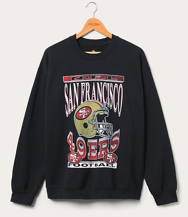 A black San Francisco 49ers sweatshirt with a vintage graphic hangs on a wooden hanger against a plain white background.