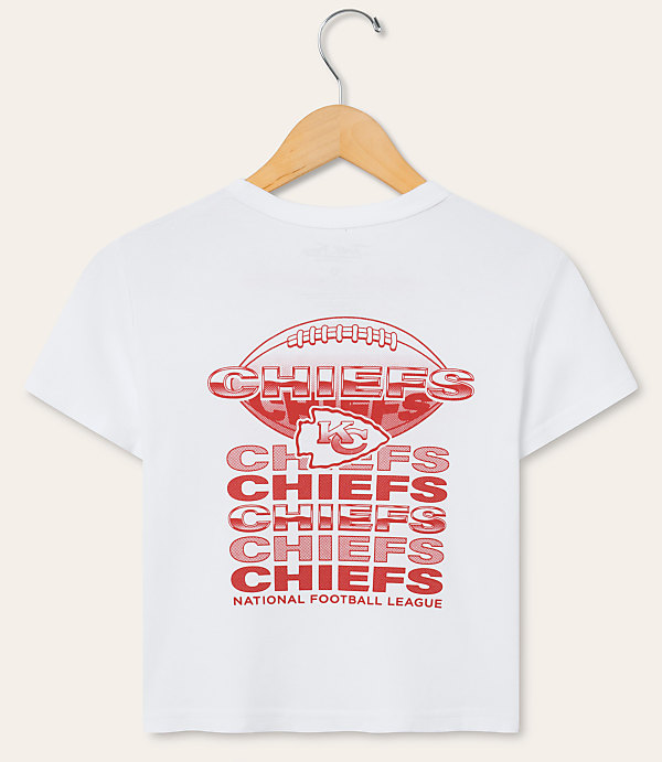 A white t-shirt with a red Kansas City Chiefs logo and repeated "Chiefs" text is displayed on a wooden hanger against a plain white background.