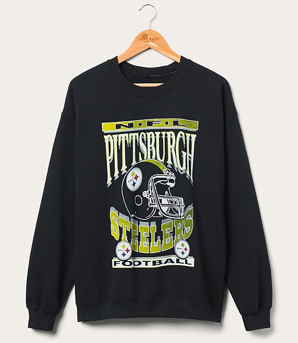 A black Pittsburgh Steelers sweatshirt with a graphic of a helmet and team name hangs on a wooden hanger against a plain white background.
