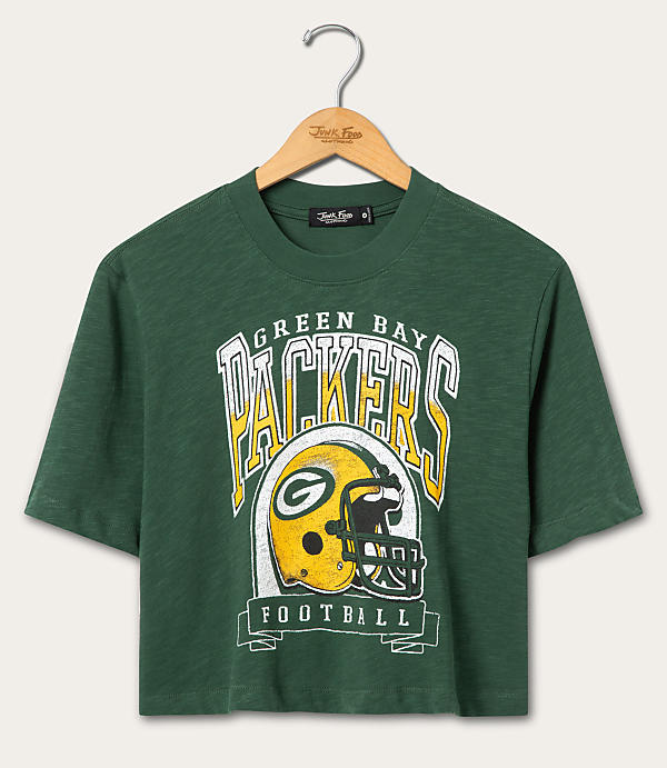 A green t-shirt with a vintage Green Bay Packers graphic hangs on a wooden hanger against a plain white background.