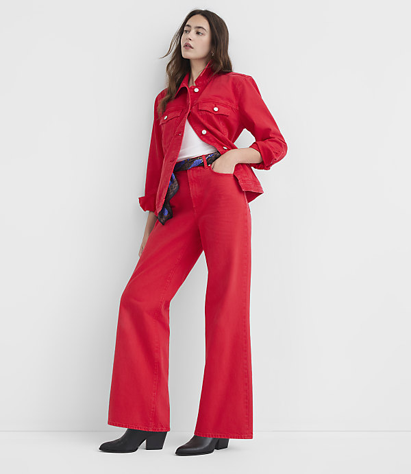 A woman in a red denim jacket and wide-leg pants stands against a plain white background.