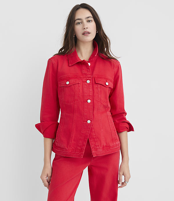 A woman in a red denim jacket and pants stands against a plain white background.