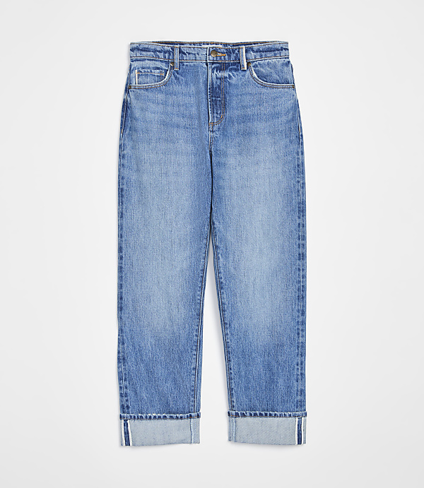 A pair of cuffed light-wash denim jeans are displayed against a plain white background.