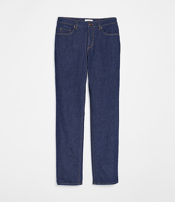 A pair of dark wash denim jeans with orange stitching lies flat against a plain white background.