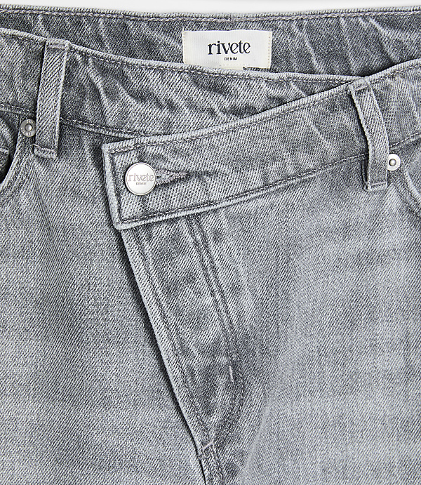 A close-up of grey denim jeans with a unique crossover waistband is presented against a plain white background.