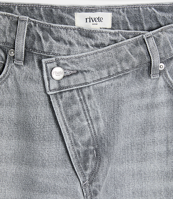 A close-up of grey denim jeans with a unique crossover waistband is presented against a plain white background.
