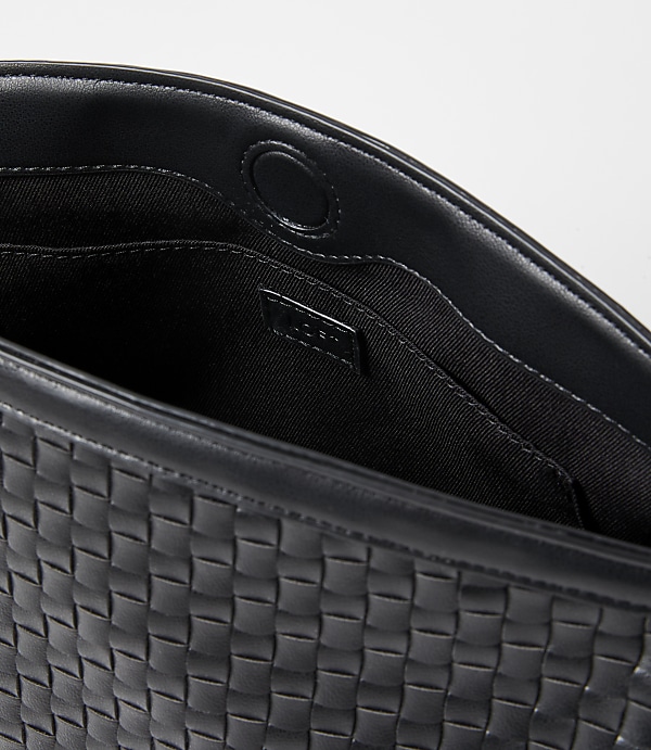 A black woven leather clutch with a snap closure is shown against a plain white background.