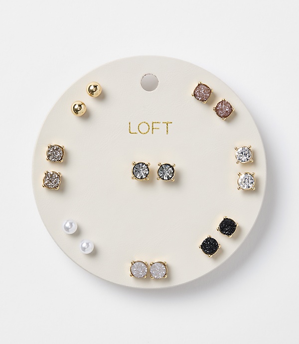 A circular white card displays a collection of assorted stud earrings, including pearls, gold balls, and various gem-encrusted designs, against a plain white background.