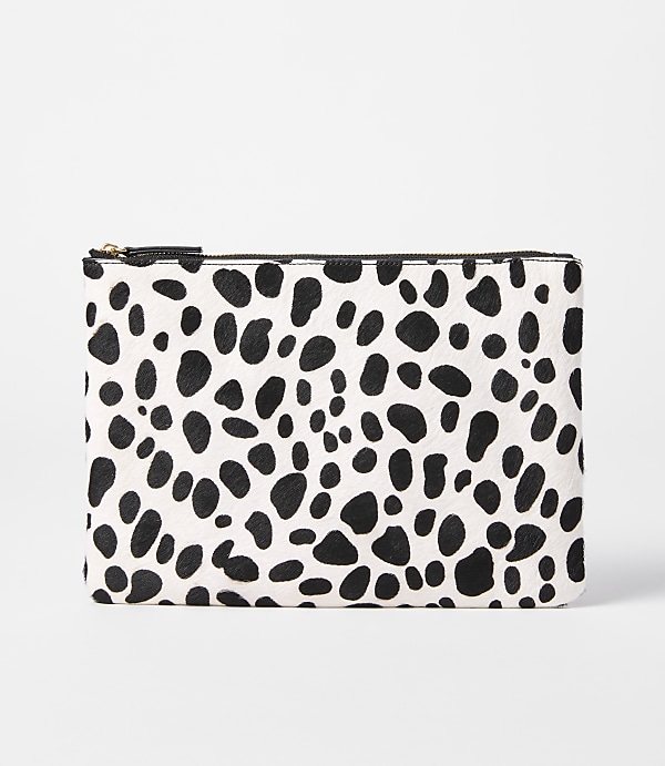 A black and white spotted clutch rests on a plain white background.